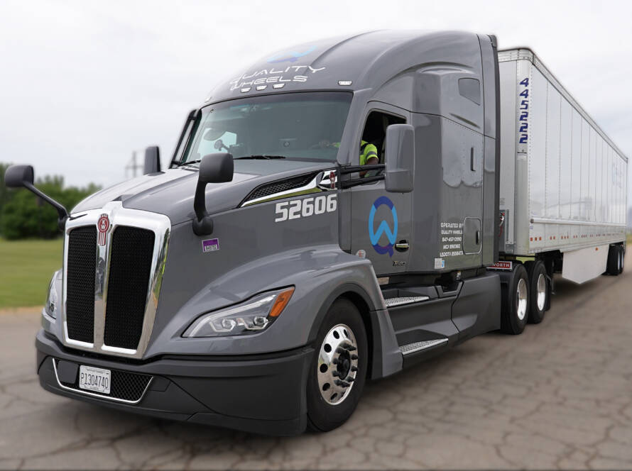 Grey Quality Wheels semi-truck with a dry van trailer ready for DOT inspections